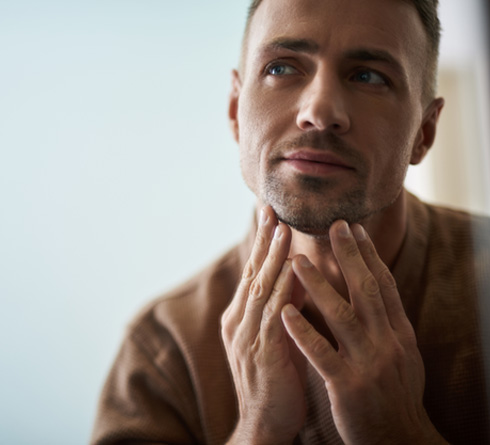 Staten Island patient noticing youthful jawline in miror after implants